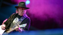 Neil Young auf der Bühne mit Gitarre