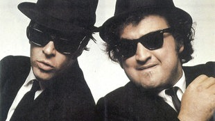 Dan Aykroyd (li.) und John Belushi sind die Blues Brothers Elwood und Jake