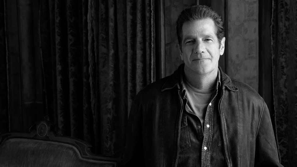 Foto von Ealgle Mitbegründer Glenn Frey rechts neben einem Sofa stehend