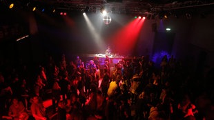 DJs und tanzende Menschen auf der Tanz in den Mai Party