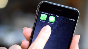 ILLUSTRATION - Auf dem Display eines iphone 6 werden die Symbole der Apps  "WhatsApp" und "Nachrichten" angezeigt