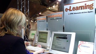 Eine Teilnehmerin der Learntec Messe im Karlsruher Kongresszentrum steht  an einem Informationsstand für E-Learning