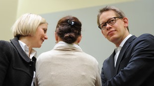 Die Angeklagte Beate Zschäpe (M) steht  im Gerichtssaal zwischen ihren Anwälten Anja Sturm und Wolfgang Heer.