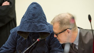 Der Angeklagte Carsten S. sitzt am 04.06.2013 im Gerichtssaal in München (Bayern) neben seinem Anwalt Jacob Hösl und verbirgt sein Gesicht hinter einer Kapuze