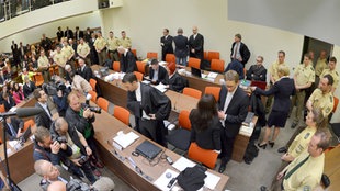 Die Angeklagte Beate Zschäpe (Gruppe rechts unten in der Mitte) steht vor Beginn des Prozesses am 06.05.2013 im Gerichtssaal in München (Bayern) neben ihren Anwälten Wolfgang Stahl (l), Wolfgang Heer und Anja Sturm (r) und dreht den Zuschauern den Rücken zu