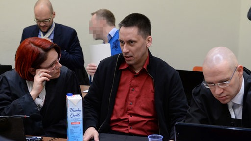 Die Angeklagten Holger G. (blauer Pullover/ 3.v.l.) und Ralf Wohlleben (2.v.r.) sitzen am 25.03.2014 im Gerichtssaal im Oberlandesgericht in München (Bayern) zwischen ihren Anwälten