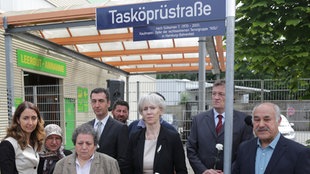Staatsministerin Aydan Özuguz(SPD, l-r), Verwandte der Familie Tasköprü, der Bundesvorsitzende von Bündnis90/Die Grünen, Cem Özdemir, Hamburgs Kultursenatorin Barbara Kisseler (l-r), der Vorsitzende der Bezirksversammlung Altona, Frank Toussaint und der Vater des NSU-Opfers, Süleyman Tasköprü, Ali Tasköprü, stehen am 26.06.2014 in Hamburg unter dem Strassenschild der "Tasköprüstrasse"