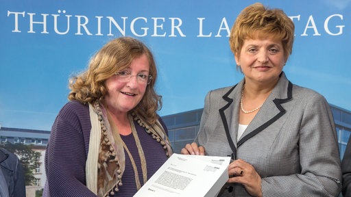 Die Ausschussvorsitzende Dorothea Marx (l, SPD) übergibt am 21.08.2014 im Landtag in Erfurt (Thüringen) der Landtagspräsidentin Birgit Diezel (CDU) den Abschlussbericht des Thüringer NSU-Untersuchungsausschusses