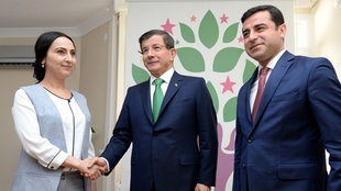 Der türkische Premierminister Ahmet Davutoglu und Vositzende der HDP Selahattin Demirtas und Figen Yüksekdag