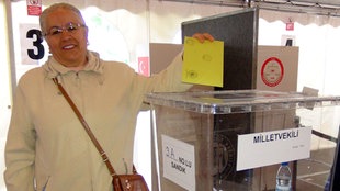 Eine Frau wirft einen Stimmzettel in die Wahlurne